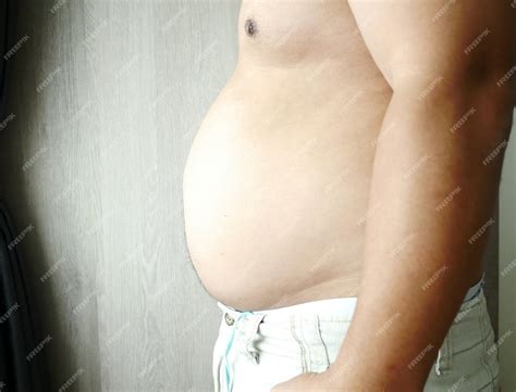 Premium Photo | Midsection of shirtless fat man at home