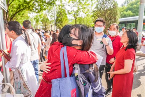 在高新区实验中学考点，海川中学初中部的老师们穿上了红色的上衣，为考生们送上首考的祝福。