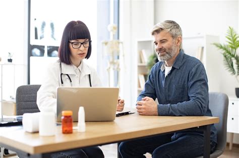 Doctor and patient discussing symptoms of illness in clinic | Premium Photo