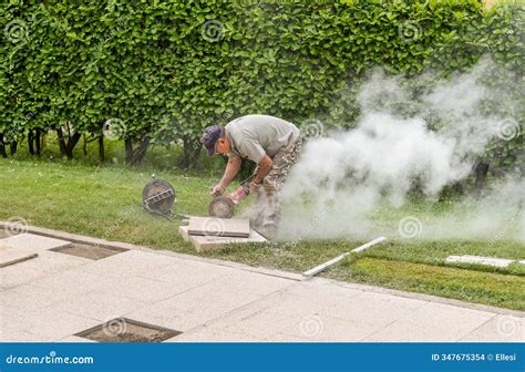 A Worker is Cutting Concrete Floor Slabs with a Circular Electric Saw ...