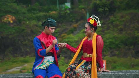 Couple in traditional Indonesian attire holding hands outdoors 47431136 ...