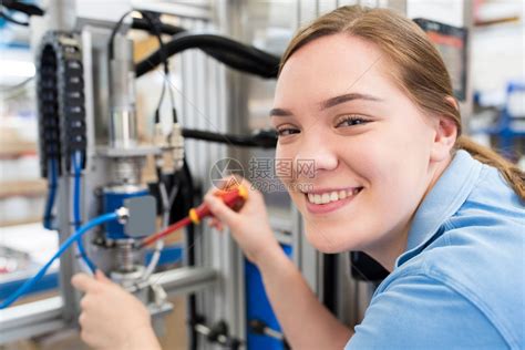商业训练二十多岁女学徒工程师在厂机器上作的肖像在工厂中作高清图片下载-正版图片307780731-摄图网