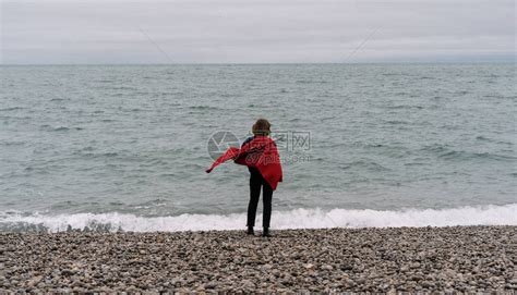 穿着红色斗篷站在海边做梦和享受美丽的风景的女旅行者背影高清图片下载-正版图片505764810-摄图网