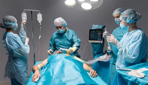 Different doctors doing a surgical procedure on a patient | Free Photo