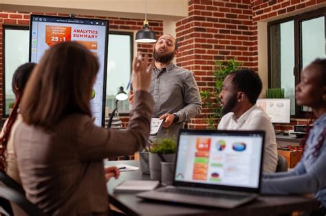Bearded man answers questions in meeting | Free Photo