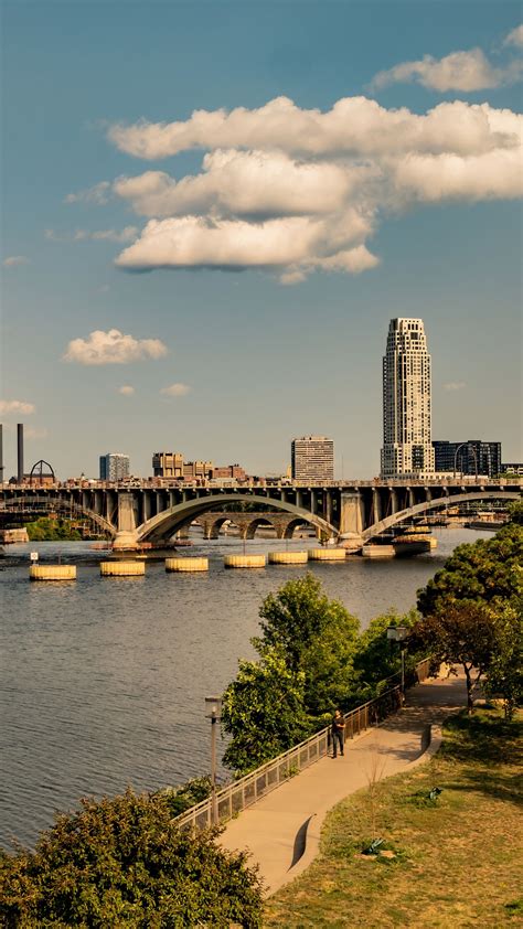 Download wallpaper 2160x3840 bridge, river, buildings, trees, clouds ...