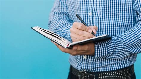 Close up of man writing in book | Free Photo
