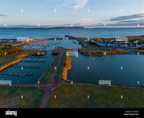 An aerial view of Burry Port coastal fishing town, including lighthouse ...