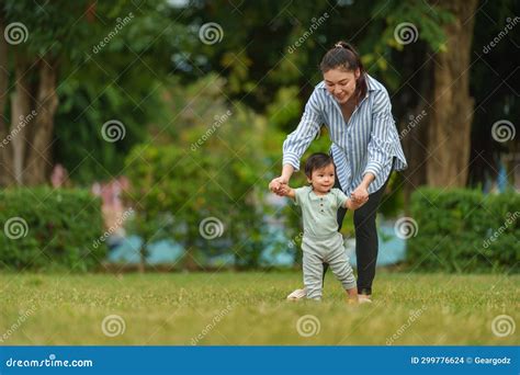 Infant Baby Learn Walking First Step on Grass Field with Mother Holding ...