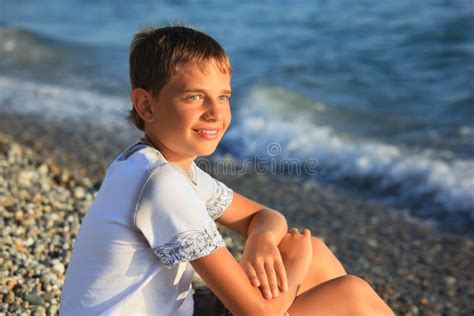 男孩海岸坐的石少年 库存图片. 图片 包括有 小卵石, 放松, 人员, 有吸引力的, 异乎寻常, 南部, 冒险家 - 11720211