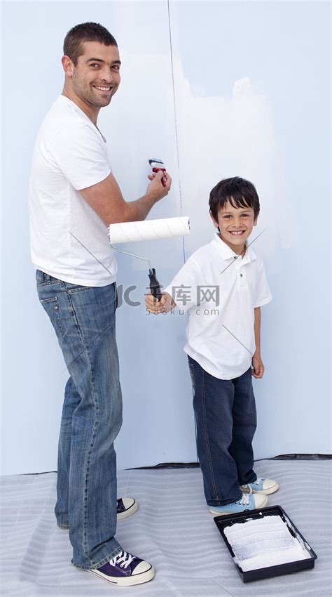 男人和小男孩在墙上刷漆高清摄影大图-千库网