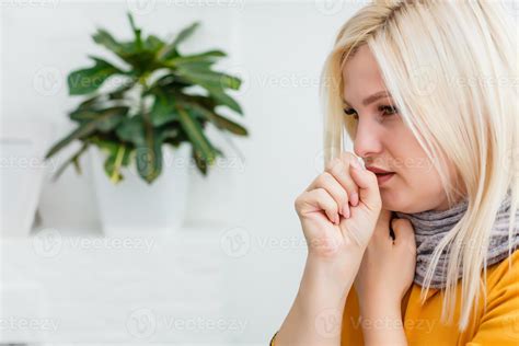 Closeup portrait of unhealthy young European blonde woman coughing a lot, suffering with cough ...