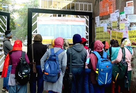 Candidates check their room numbers before entering the examination center