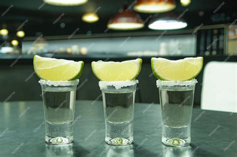 Un tiro de tequila con sal y lima tequila en el fondo de una playa ...