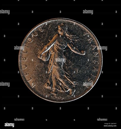 A closeup of a 5 francs coin from 1991 isolated on a black background, the former French ...