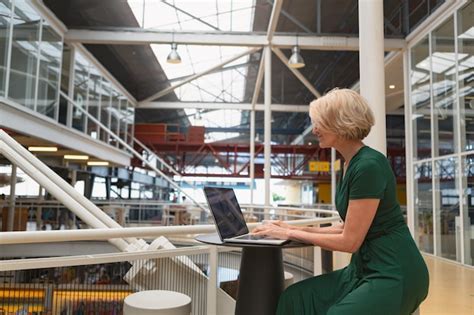 Businesswoman using laptop in the corridor at office | Premium Photo