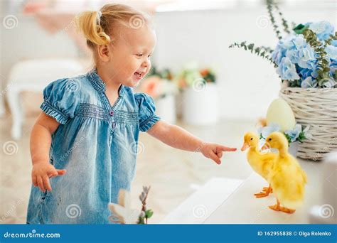 Blondel Little Girl in Blue Dress and Two Ponytales Playing with Yellow ...