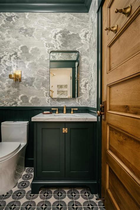 a bathroom with black and white tile flooring and green cabinetry on ...