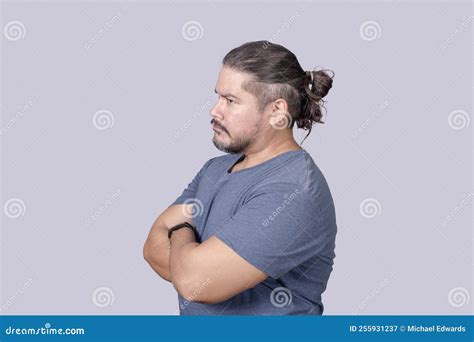 A Bitter Man in His 30s Looking Sideways with a Scowling Face and Arms ...