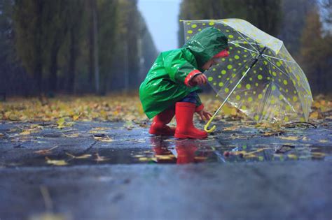 水坑旁边的小男孩图片-小男孩拿着黄色雨伞站在水坑旁边素材-高清图片-摄影照片-寻图免费打包下载