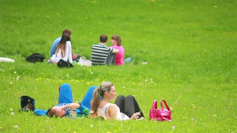young people relax in the park sitting on green grass 13549518 Stock ...