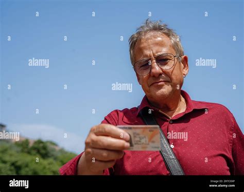 an immigrant looking at spanish national identity document. an old man ...