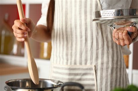 Cooking woman in kitchen with wooden spoon cooking woman | Premium Photo
