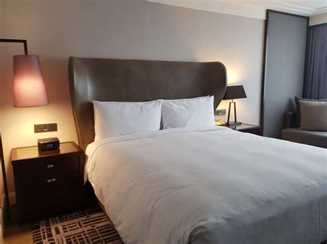 JW Marriott bed in hotel room with logo on an accent pillow