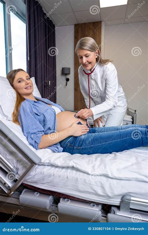 Pregnant Woman Lying on the Couch while Doctor Listening To Babys Heartbeat Stock Photo - Image ...