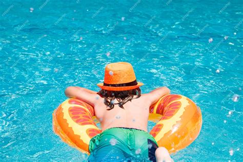 Premium Photo | Child boy swim with floating ring in swimming pool kids ...