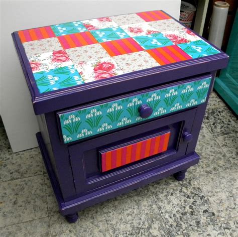 a purple table with colorful designs on it sitting next to a white wall ...