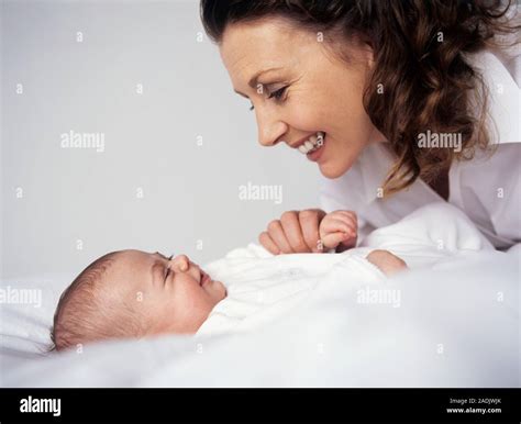 Mother and baby girl. Mother and her 12-week-old baby girl smiling as ...