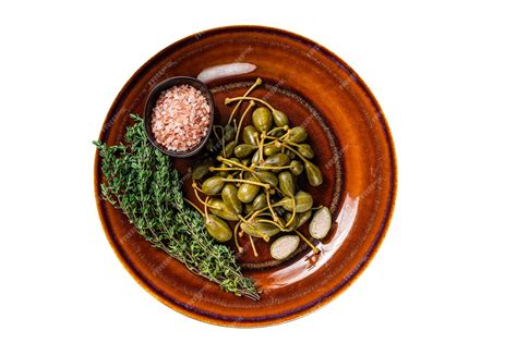 Premium Photo | Marinated canned capers berries in a rustic plate isolated white background top view