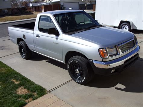 2000 Nissan Frontier Truck with Silver Pick Up Truck and White Trailer