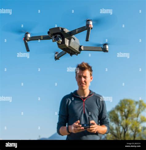 Young man controlling flying quadrocopter, remote controlled drone with ...