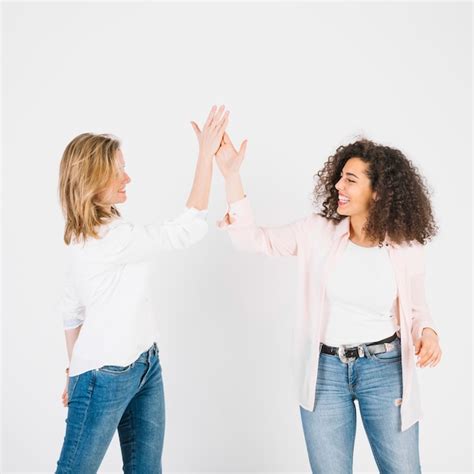 High-fiving women on white | Free Photo