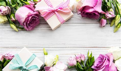 Pink roses and gift boxes on white wooden background | Premium Photo