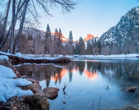 Un lac entouré de rochers, d'arbres et de montagnes à Yosemite en hiver ...