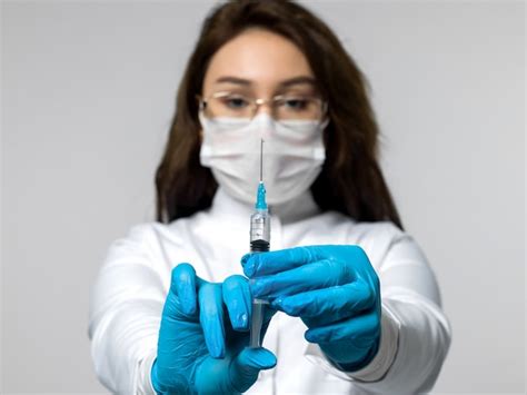 Nurse prepares an injection wearing a uniform | Free Photo