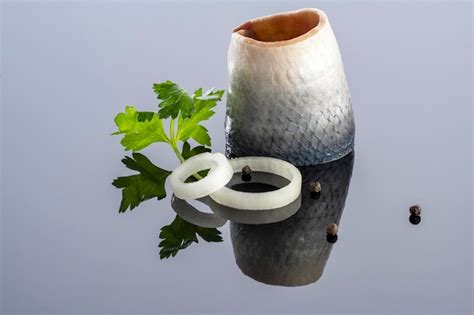 Pieces of salted herring fish on a mirror background | Premium Photo