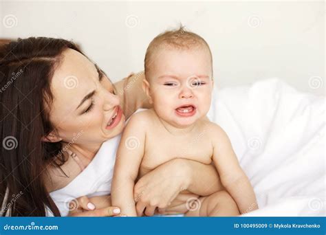 Young Funny Mom Playing the Ape Her Baby Crying Lying in Bed at Home ...