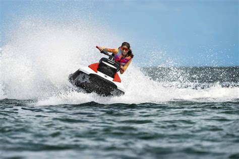 A woman performing a stunt on her Sea-Doo Spark with the words “Make Waves sales event”