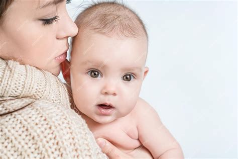 Premium Photo | Young woman holding a baby on a white background