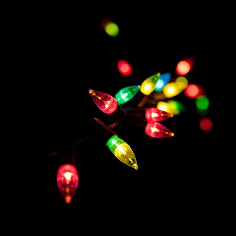 A string of colorful christmas lights on a dark background | Premium Photo