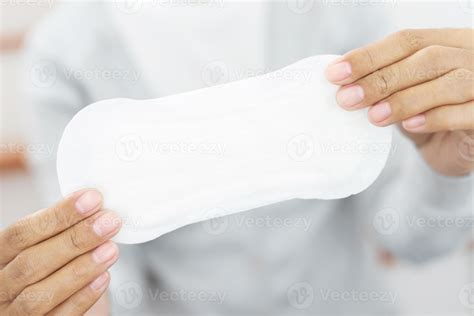 Female Hygiene. Close Up Young woman holding a Clean Period slim sanitary napkin pad. Reports ...
