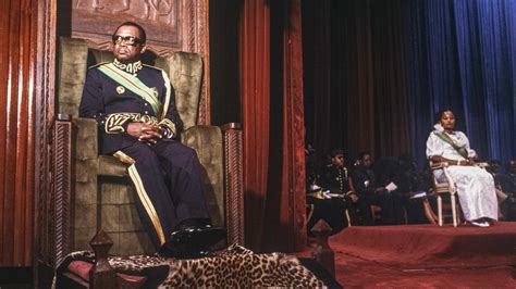 Dictator of Zaire Mobutu Sese Seko sitting on his throne across from his wife, waiting to take ...