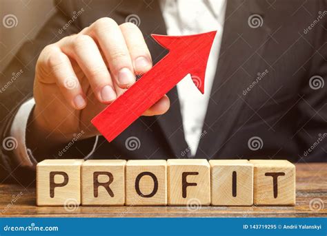 A Businessman Holds a Red Arrow Up Over Wooden Blocks with the Word ...