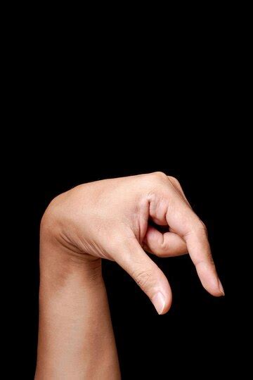 Hand gesture representing down or under on a black background | Premium ...
