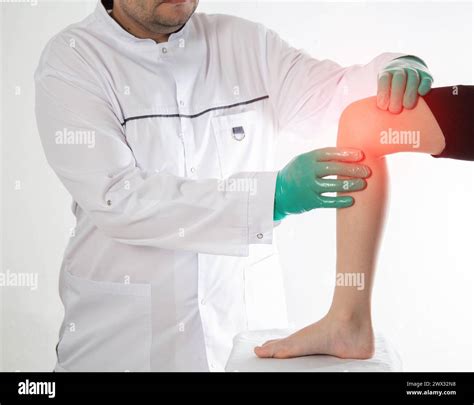 A doctor traumatologist orthopedist examines the knee joint of a child who has knee pain ...