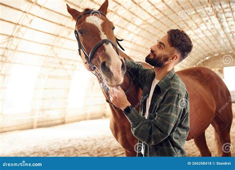 Standing Together. Young Man with a Horse is in the Hangar Stock Photo ...